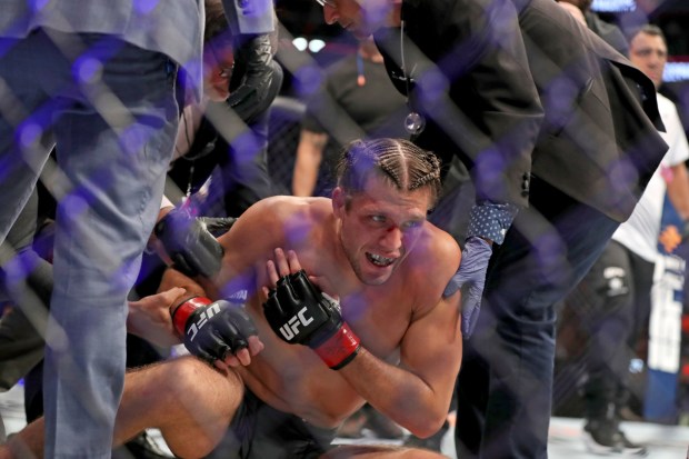 Brian Ortega is seen on the canvas with doctors after suffering a shoulder injury against Yair Rodriguez during their UFC on ABC 3 main event Saturday, July 16, 2022, in Elmont, N.Y. (AP Photo/Gregory Payan)