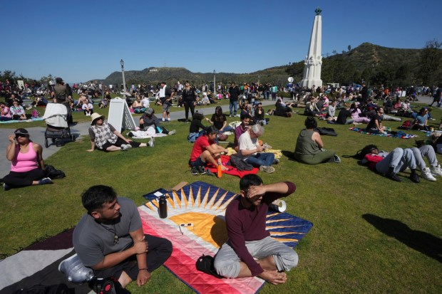 Spectators use special glasses to watch a solar eclipse at the Griffith Observatory on Monday, April 8, 2024, in Los Angeles. (AP Photo/Damian Dovarganes)