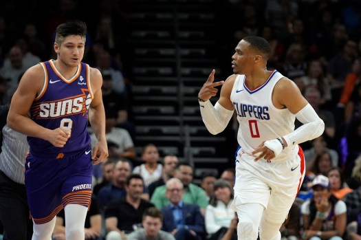 Clippers guard Russell Westbrook, right, celebrates after making a 3-point shot as he runs past Phoenix Suns guard Grayson Allen during the first half on Tuesday night in Phoenix. Westbrook had 16 points, 15 rebounds and 15 assists for his first triple-double of the season in a 105-92 win. (AP Photo/Ross D. Franklin)
