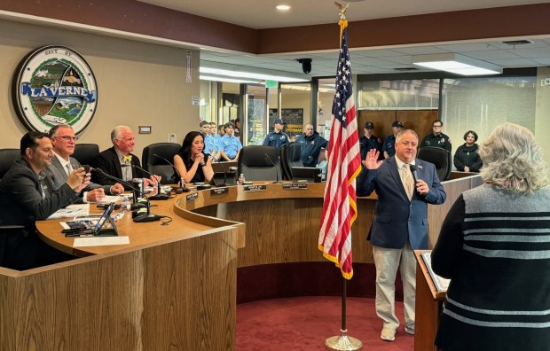 Rick Crosby takes the oath of office for his second term on the La Verne City Council from Deputy City Clerk Debra Fritz on Monday night. At left, Councilmember Meshal Kashifalghita snaps a photo of the proceedings. (Photo by David Allen, Inland Valley Daily Bulletin/SCNG)