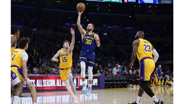 Golden State Warriors guard Steph Curry shoots in front of Lakers guard Austin Reaves (15) and forward LeBron James (23) during the first half on Tuesday night at Crypto.com Arena. (AP Photo/Ryan Sun)
