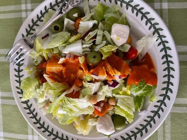 This crunchy shopped salad, made with coarsely chopped hearts of romaine and raw cabbage, is topped by a roasted red pepper dressing. (Photo by Cathy Thomas)