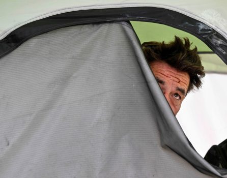 Robert Simmons, 56, peers out of a tent in the City Creek area off Highway 330 in San Bernardino on Thursday, July 28, 2022, as he speaks with a San Bernardino County Sheriff’s deputy. (File photo by Will Lester, Inland Valley Daily Bulletin/SCNG)

